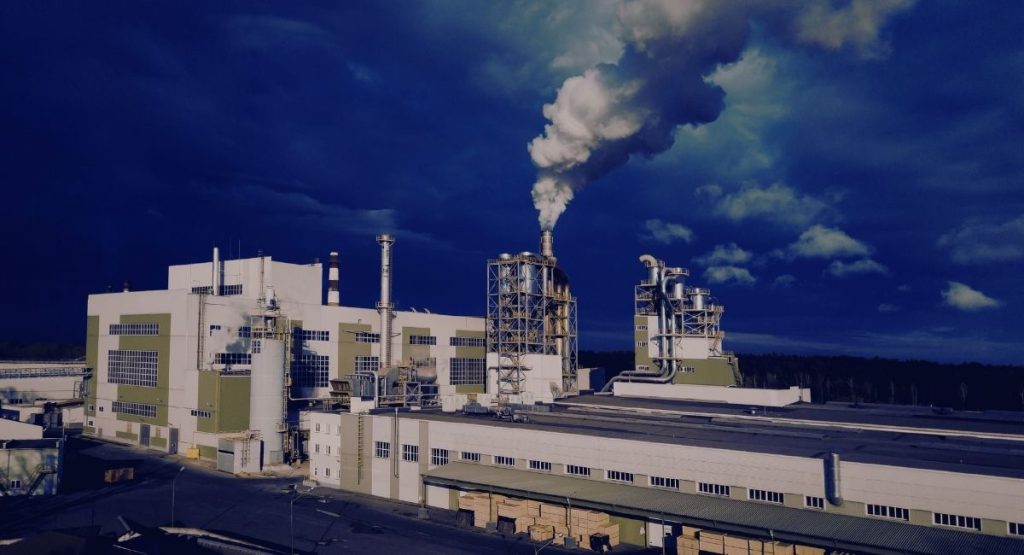 Cheminées d'une usine rejetant des panaches de vapeur dans un ciel gris
