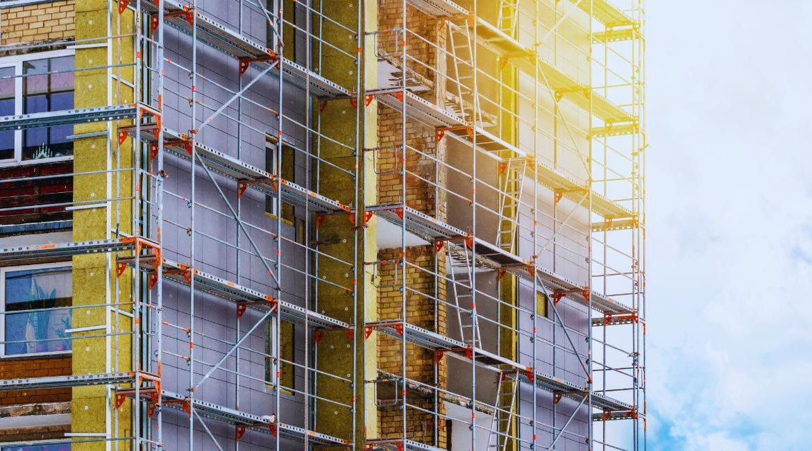 Échafaudage sur une façade en cours d'isolation thermique par l'extérieur avec de la laine minérale